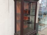 a glass display case with a clock inside of it