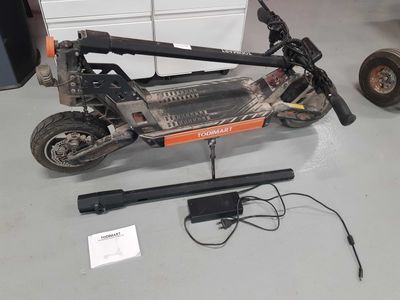 a scooter that is sitting on the floor next to a remote control
