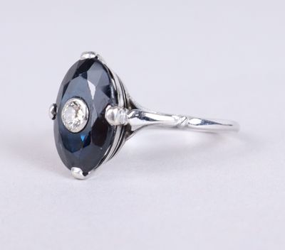 gros plan d'une bague avec une pierre bleue et des diamants