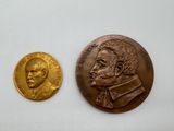 une image représentant une médaille d'or et une pièce de bronze sur un fond blanc