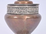 un vase en argent avec un couvercle, sur fond blanc