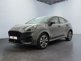 une voiture grise garée dans une grande pièce aux murs blancs