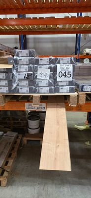 une grande quantité de bois d'œuvre empilée sur des palettes dans un entrepôt