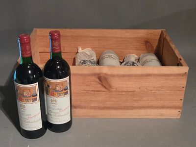 deux bouteilles de vin dans un coffret en bois à côté d'une bouteille de vin