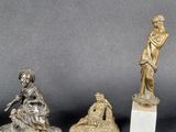 three bronze figurines of a woman and a man on a marble base