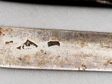 a knife that is laying on a table next to a knife