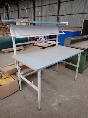 une table surmontée d'une étagère, dans un entrepôt