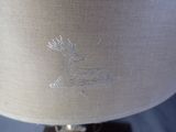 a close up of a lamp with a deer embroidered on it
