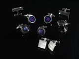 six pairs of cufflinks with blue and red stones on a black surface