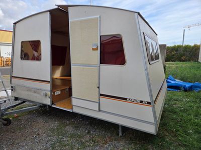 an image of a camper trailer parked in the grass