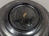 a black vase with a gold writing on it