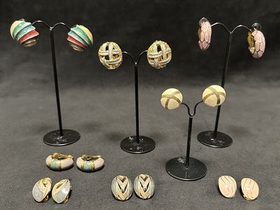 five pairs of earrings that are sitting on a stand