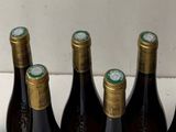 several bottles of wine are lined up in a row on a counter