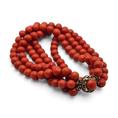 gros plan d'un collier de perles rouges sur fond blanc
