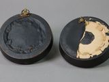 pair of black and gold painted wooden boxes with a hole in the middle