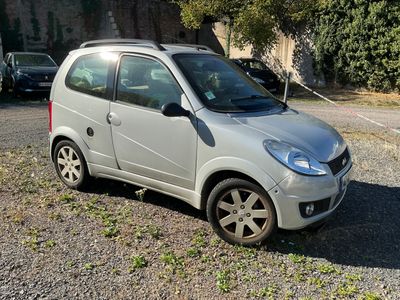 une petite voiture argentée garée sur le bord de la route
