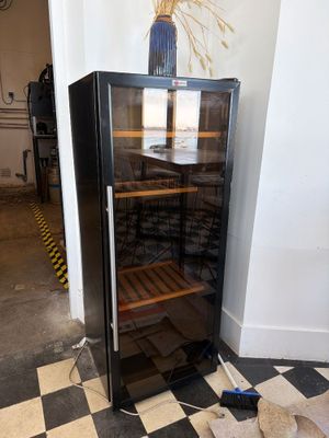 a wine cooler that is sitting in the corner of a room