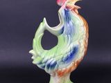a close up of a figurine of a rooster on a black background