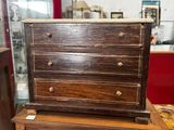 une petite commode en bois posée sur une table