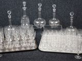 bottles and glasses are lined up on a tray on a table