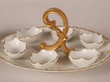 a white and gold plate with a gold spoon on it