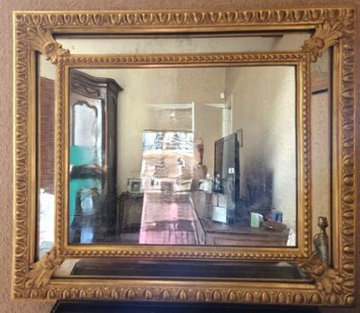 le reflet d'une voiture dans un miroir accroché au mur