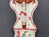 a wall clock that has a crucifix on it