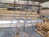 an image of a ladder in a warehouse with pallets of wood