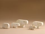 trois petites figurines d'éléphants blanches posées sur une table