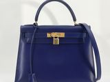 un sac à main bleu muni d'un fermoir doré sur la poignée
