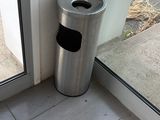 une poubelle devant une porte vitrée