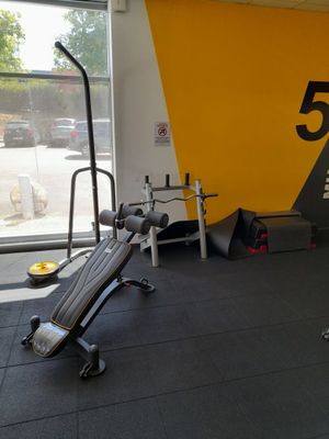 une salle de sport avec un banc, des poids et d'autres équipements