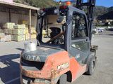 a forklift truck parked in a parking lot in front of a store