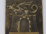 une plaque métallique surmontée d'un dragon