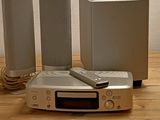 trois haut-parleurs et une télécommande posés sur une table en bois