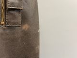 someone is holding a brown bag with a zipper on it