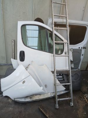 une camionnette blanche contre laquelle est appuyée une échelle