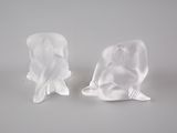 deux sculptures représentant un homme et une femme assis sur une surface blanche