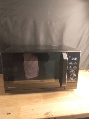 un micro-ondes posé sur une table recouverte d'une serviette