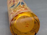 a glass bottle with a yellow liquid inside of it
