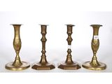 three brass candlesticks are sitting side by side on a white background