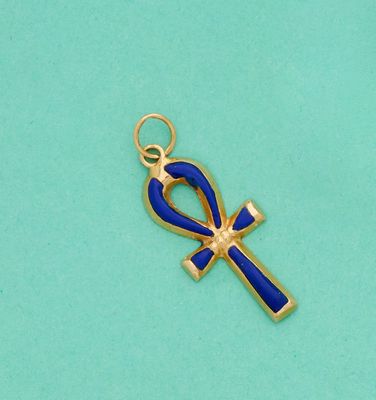 un pendentif en forme d'ankht doré et bleu sur fond turquoise