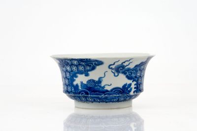 un bol bleu et blanc posé sur une surface blanche