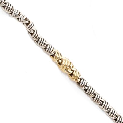 a close up of a silver and gold bracelet on a white surface