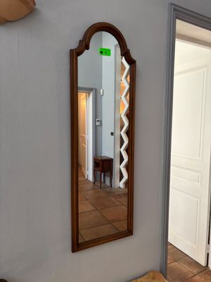 un miroir accroché au mur au-dessus d'un banc dans une pièce
