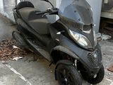 un scooter garé sur un parking à côté d'un immeuble