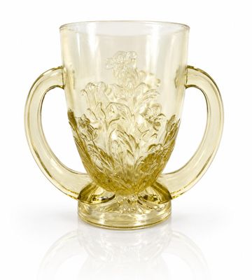 a yellow glass cup with a handle on a white surface