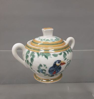 a white and green teapot with a bird on it