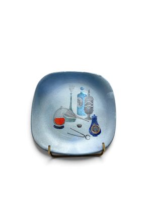 une assiette bleue sur laquelle est représenté un ensemble d'instruments dentaires