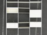 an overhead view of a white bookcase with drawers and shelves